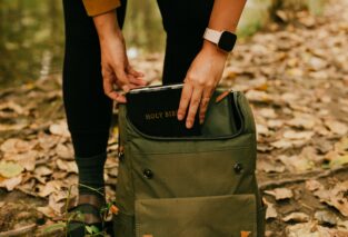 Girl putting bible in backpack